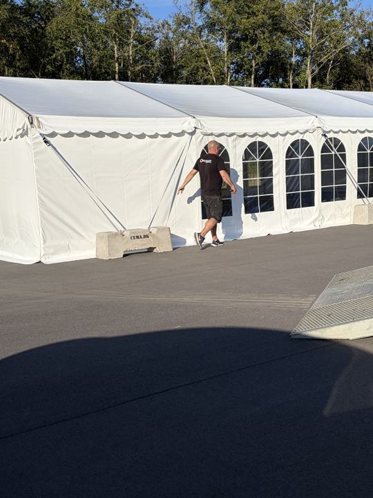 Festtelt på asfalt sikret med betonklodser