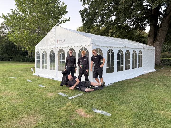 Holdet fra Centrum Festudlejning foran et opstillet festtelt i en park