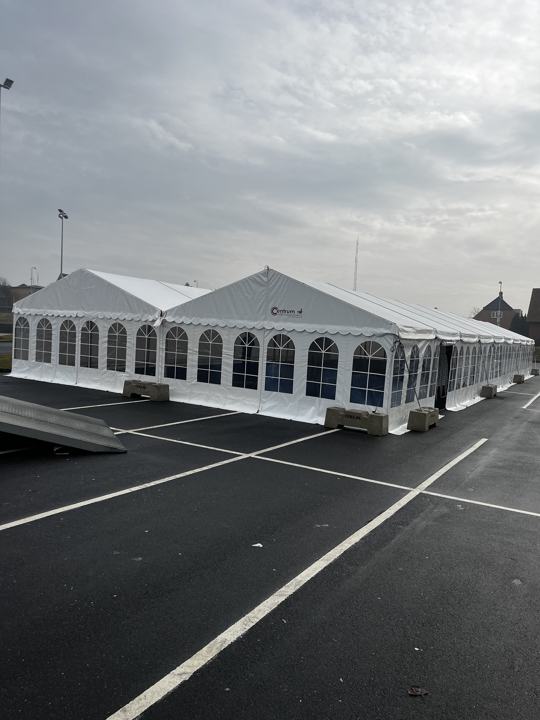 Stort festtelt i dobbelt bredde på asfalt med betonklodser
